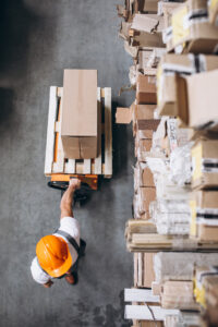 Young man working at a warehouse with boxes. Designed by Freepik